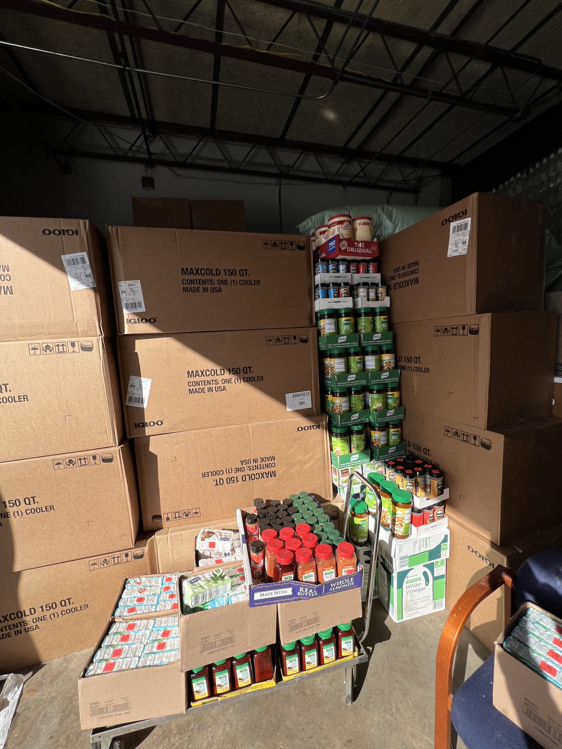 MACONA warehouse stacked with boxes of food, canned goods, and cooking oil ready for shipment