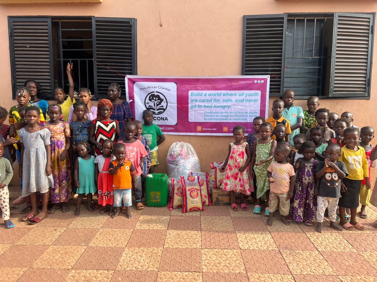 Group photo of children with food outside the orphanage